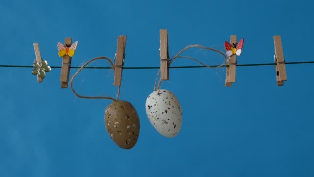 The-Easter-Eggs-is-hanging-on-the-clothesline-on-blue-background.