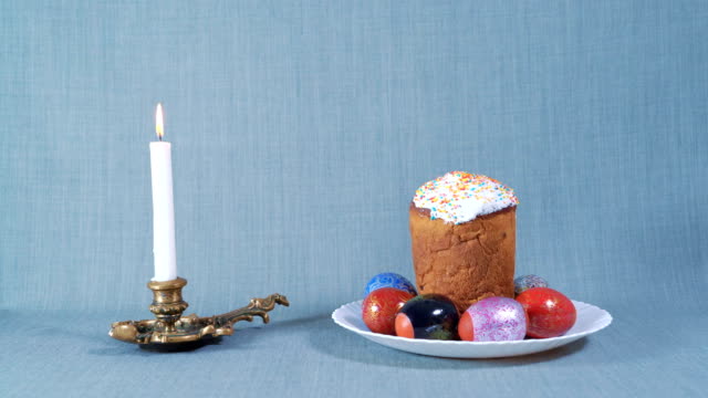 Easter-Arrangement,-Easter-in-the-White-Plate-with-Dyed-Eggs,-Nearby-Burning-White-Candle