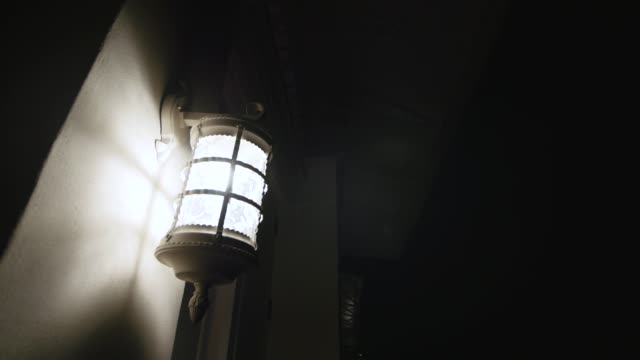 Antique-illuminated-street-lantern-at-night-on-the-wall