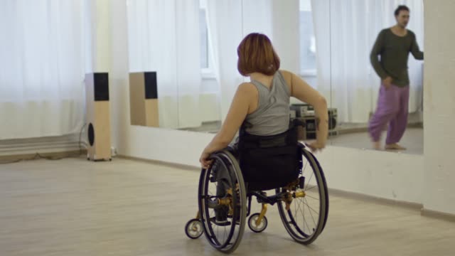 Schöne-Frau-mit-gelähmten-Beinen-tanzen-im-Rollstuhl