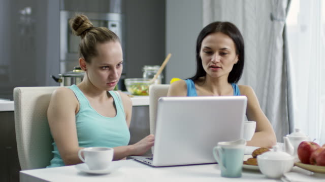 Female-Couple-with-Laptop-Having-Breakfast