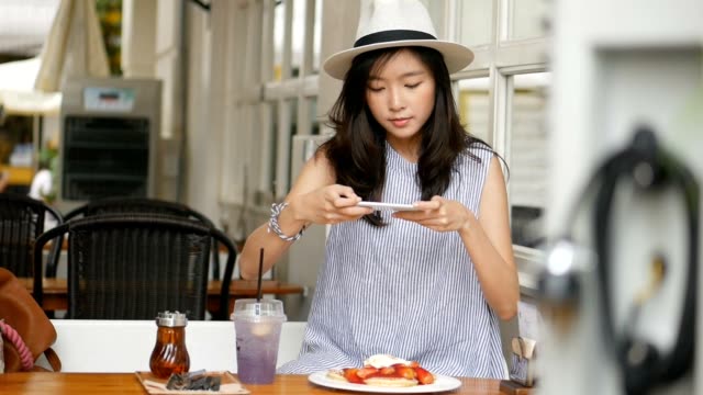 Young-asian-woman-take-a-photo-pancake-at-cafe.-Technology-and-social-networks-concept.