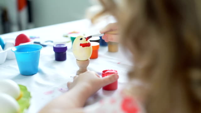 Little-Girl-hat-Spaß-daran,-Ostereier-zu-malen