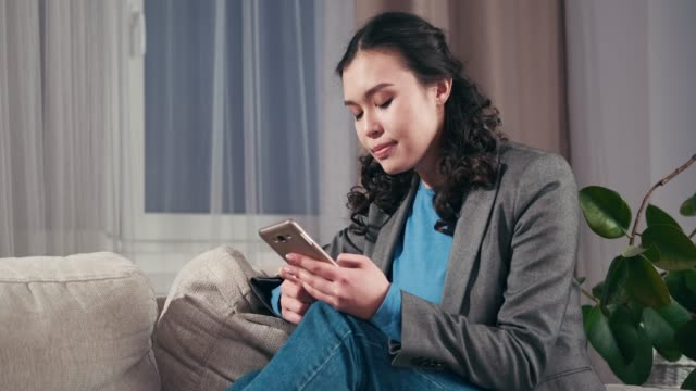 Traurige-Geschäftsfrau-Textnachrichten-auf-Handy-zu-Hause