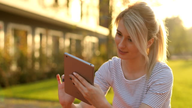 Young-female-student-with-tablet-computer-in-the-park.