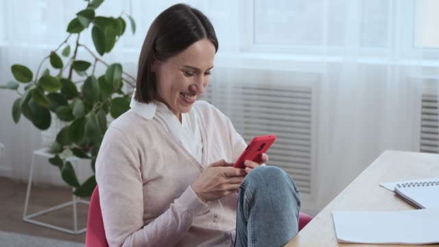 Woman-laughing-while-using-mobile-phone