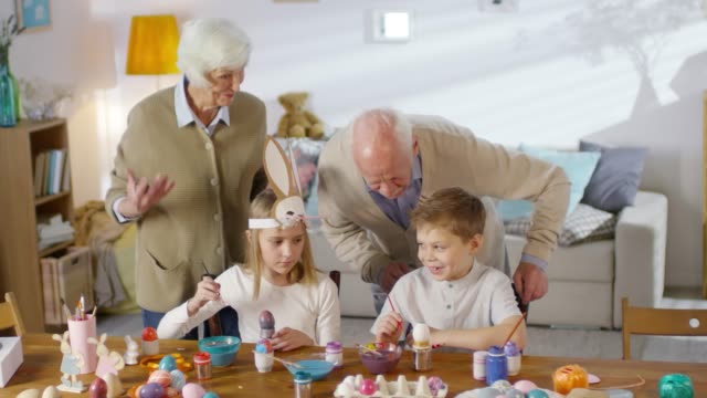 Grandparents-Watching-Grandchildren-Paint-Eggs