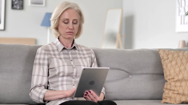 Old-Senior-Woman-Using-Tablet-at-Workplace