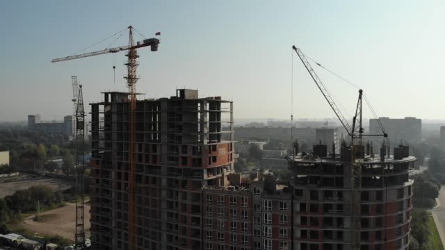 Una-vista-aérea-de-un-edificio-residencial-en-construcción.-Grúas-torre-que-trabajan-en-el-edificio.-4K