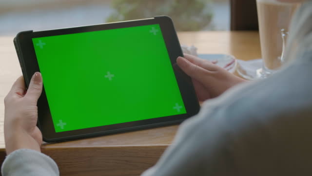 Geschäftsfrau-mit-Tablet-Computer-mit-grünem-Touchscreen-im-Café
