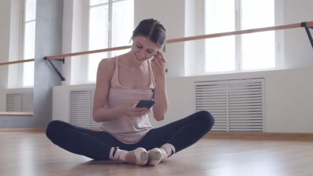 Junge-Ballerina-Messaging-mit-Telefon-in-Studio