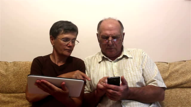 Atractivo-adulto-mujer-y-hombre-adulto-trabajan-en-la-tableta-PC-y-teléfono-inteligente.