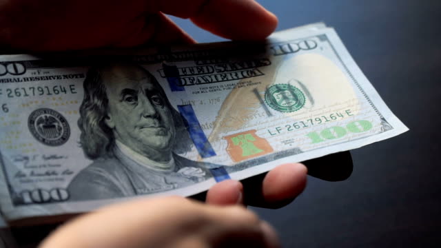 Us-dollar-bills-being-counted-by-hand-in-slow-motion