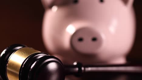 Pan-of-Piggy-Bank-and-Gavel-on-Dark-Wood-Surface