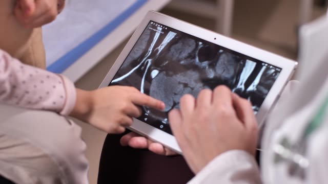 Médico-sosteniendo-tableta-con-escáneres-cerebrales-en-la-pantalla