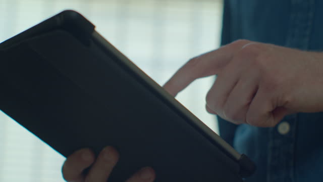 Man-using-tablet-computer-online-shopping-working-from-home.-Close-up.