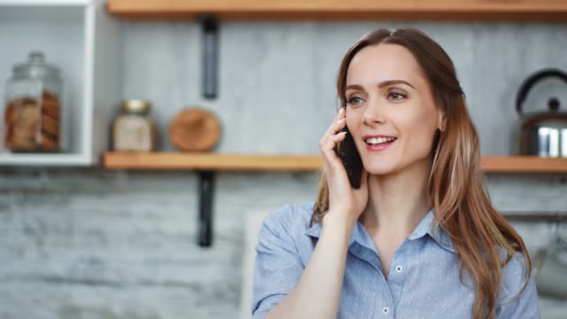 Close-up-face-adorable-blonde-girl-communicating-on-telephone-at-kitchen.-Shot-with-RED-camera-in-4K