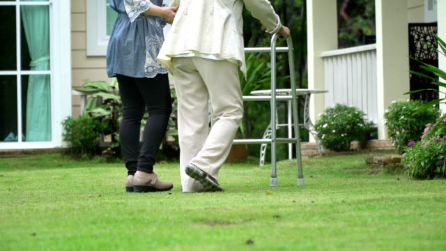 Elderly-woman-exercise-walking-in-backyard-with-daughter