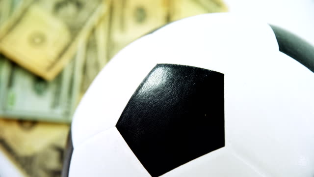Football-and-dollar-on-white-background-4k