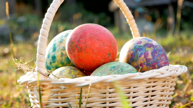 Primer-plano-de-la-cesta-con-colorido-una-Pascua-huevos-sobre-la-hierba-en-fondo-sol