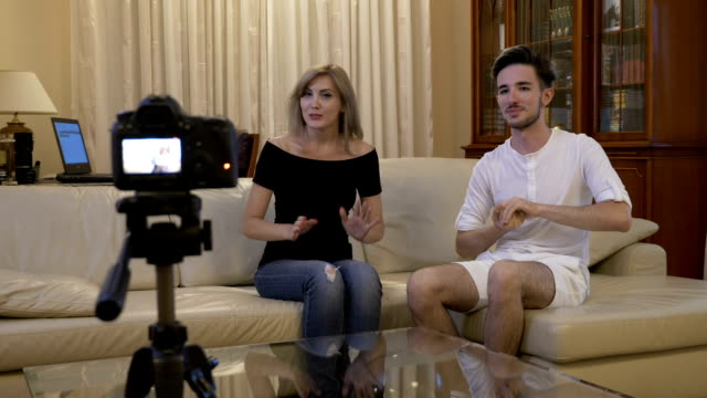 Attraktives-junges-Paar-von-Vlogger-Aufnahme-ein-neue-Videos-Tutorial-auf-social-Media-zu-Hause-auf-der-Couch-zu-fördern