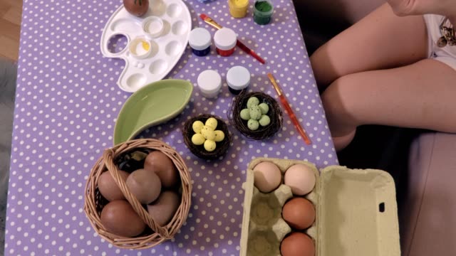 Mujer-en-la-mesa-de-Pascua-huevos-decorados