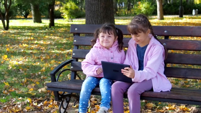 Children-with-a-gadget-on-nature.-Children-play-with-the-tablet