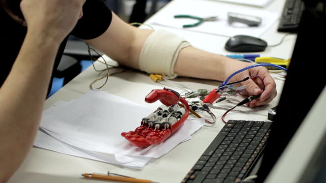 Male-professional-testing-bionic-hand-on-the-table
