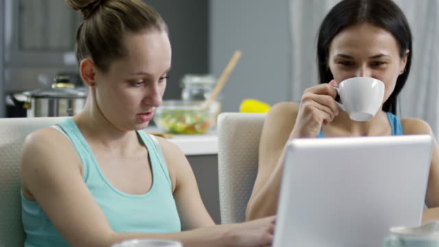 Mujer-mostrando-algo-en-la-computadora-portátil-a-pareja-femenina