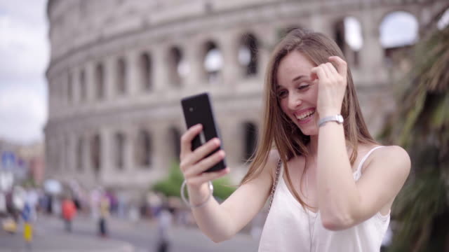 Turismo-mujer-tener-video-chat-mostrando-auténtico-ver-compartir-viajar-experiencia-usando-el-teléfono-inteligente-que-conecta-con-amigos-en-vacaciones-de-verano-los-medios-de-comunicación-social-en-Roma-Italia