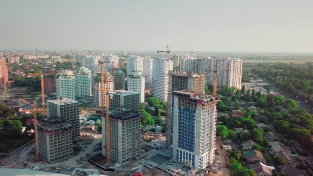 Aerial-drone-shot.-Construction-of-high-rise-buildings-in-the-developing-area-of-a-large-city.-construction-cranes-and-many-houses-under-construction