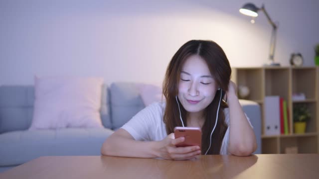 Asiática-mujer-con-celular-en-la-sala-de-estar