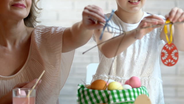 Mutter-und-Tochter-Dekoration-Zweige-mit-handgefertigten-Spielzeug-Eier-auf-Osternacht