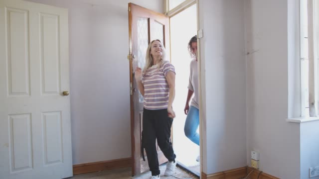 Excited-Female-Couple-Opening-Front-Door-Of-New-Home
