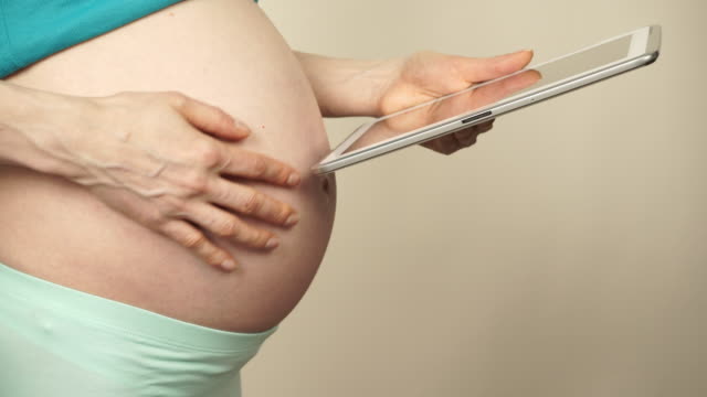 Pregnant-woman-using-digital-tablet-4K
