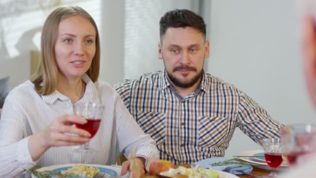 Ehepaar-klinkt-Brille-mit-Eltern-beim-Abendessen