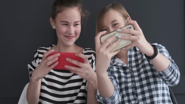 Mädchen-spielen-Spiel-auf-Mobiltelefonen
