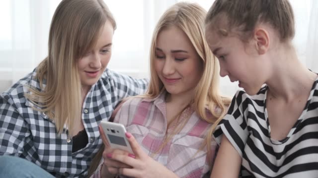 Mädchen-aus-Teenagern-beobachten-Social-Media-Inhalte-auf-dem-Handy