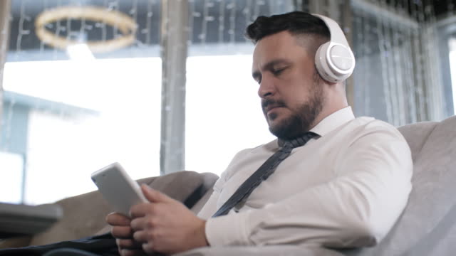 Hombre-de-negocios-caucásico-en-auriculares-usando-Tablet