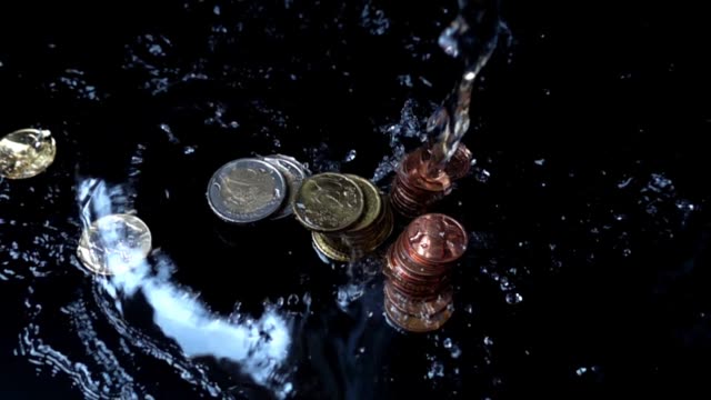 The-water-jet-falls-on-coins.-Slow-motion.
