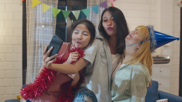 Gruppe-von-asiatischen-Frauen-Party-zu-Hause,-Weiblich-mit-Handy-machen-Vlog-Selfie-zu-sozialen-Medien,-während-lustige-tanzen-zusammen-im-Wohnzimmer-in-der-Nacht.-Junge-Freundin-feiern-Urlaubskonzept.-zeitlupe