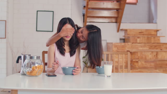 Asiatische-lesbische-Paar-geben-Geschenk-Überraschung-an-ihrem-Geburtstag-oder-Valentinstag-beim-Frühstück-in-der-Küche-am-Morgen.