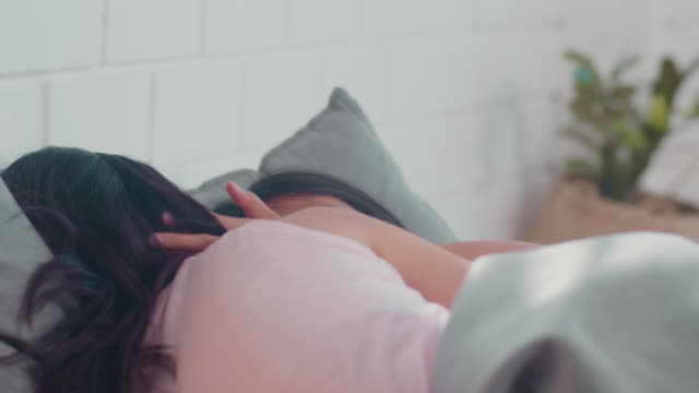 Asiatische-Lesbische-Paar-entspannen-sich-zusammen-nach-dem-Aufwachen-liegend-auf-dem-Bett-im-Schlafzimmer.