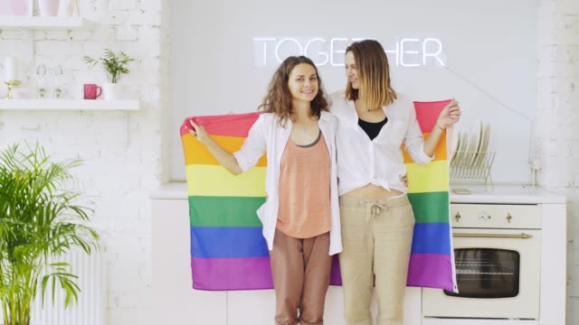 Girlfriends-with-rainbow-flag-in-apartment