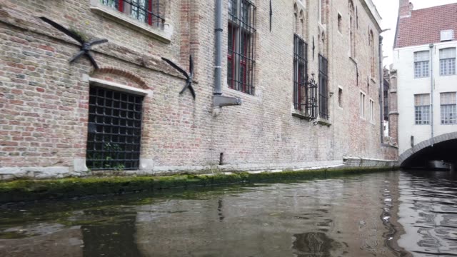 Brujas,-Bélgica---Mayo-2019:-Vista-del-canal-de-agua-en-el-centro-de-la-ciudad.-Paseo-turístico-por-los-canales-de-agua-de-la-ciudad.-Vista-desde-un-barco-turístico.