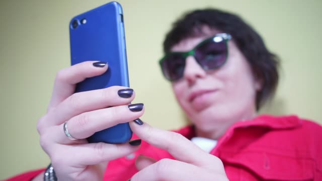 blaues-Smartphone-in-den-Händen-eines-Mädchens-in-rot