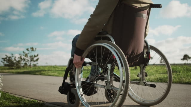 Outdoor-walk-of-disabled-man-in-wheelchair