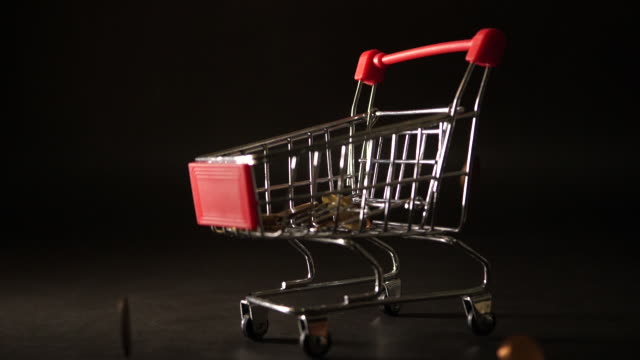 Coin-falling-down-on-mini-shopping-cart