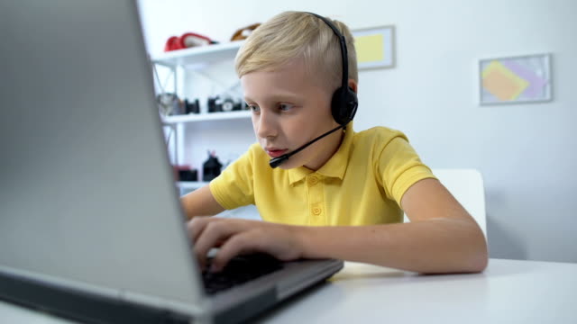 Süchtige-männliche-Kind-in-Headset-spielen-Spiel-auf-Laptop-Computer-moderne-Technologien