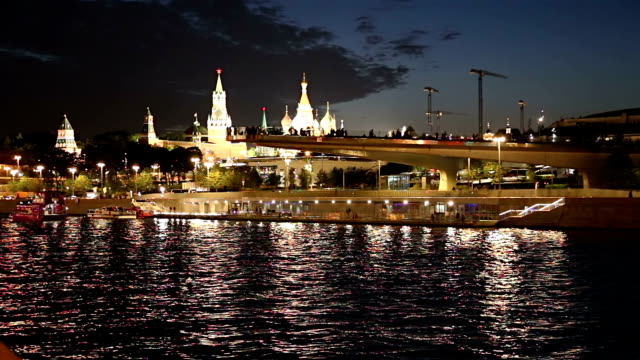 Schwimmende-Brücke-von-Zaryadye-Park-auf-Moskvoretskaya-Embankment-des-Flusses-Moskva-(und-touristisches-Vergnügungsboot)-bei-Nacht.-Moskau,-Russland.